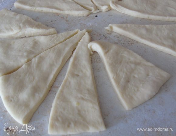 Делим тесто на 4 части, каждую раскатываем и разрезаем на сегменты (8 частей).