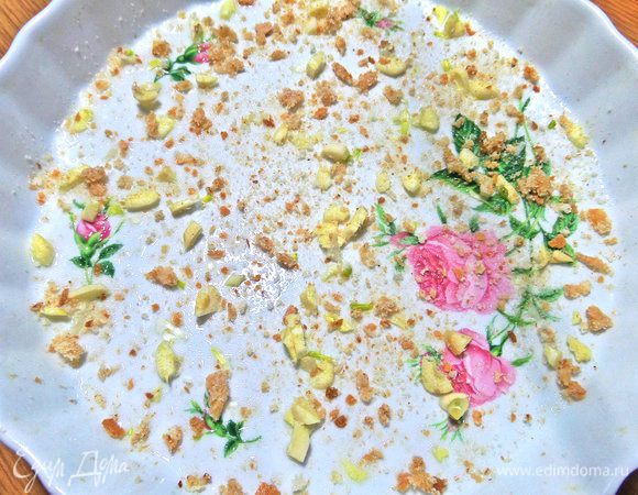 Форму 22 см в диаметре смазать маслом, обсыпать сухарями и покрошить на дно чеснок, можно крупно в данном случае.