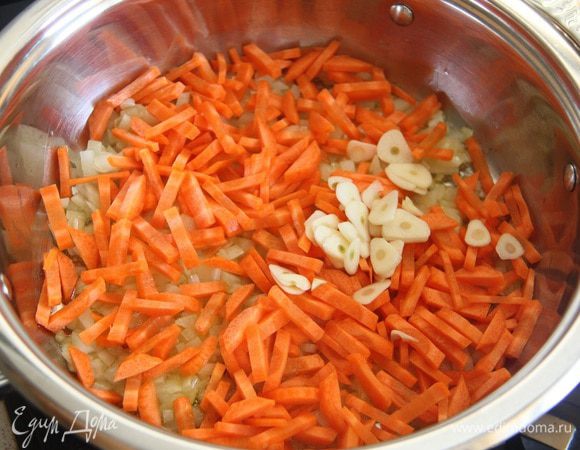 Добавить нарезанную брусочком морковь, чеснок слайсами.