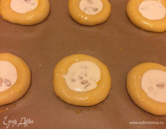 В каждом колобке сделать углубление, бока смазать желтком, а в центр выложить крем.