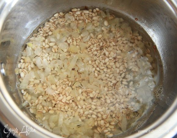 Промытую перловую крупу положить в кастрюлю к луку, добавить 2-3 половника овощного бульона. Варить на слабом огне до готовности (минут 20-25).