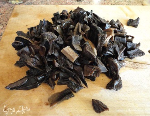 Грибы залить кипятком (2,5 стакана) на ночь. Утром отварить в этой же воде. Достать из бульона и нарезать.