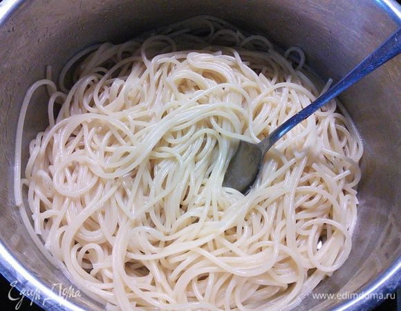 Спагетти отварить в большом количестве подсоленной воды (аль денте). Когда спагетти готовы, откинуть на дуршлаг, промыть под холодной водой, переложить обратно в кастрюлю и добавить оливковое масло, перемешать. 