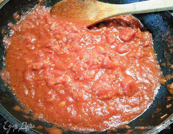 Пока варятся спагетти, приготовим соус. Для этого мелко порубить лук и чеснок и пассеровать в разогретом масле. Добавить томатную пасту и обжарить в течение минуты, влить помидоры в собственном соку, предварительно их размять. Всыпать травки и тушить соус минут 5. В конце посолить, поперчить и добавить щепотку сахара по вкусу. 