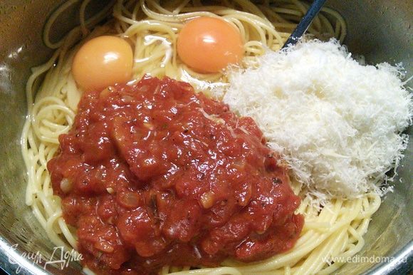 Когда спагетти чуть остынут, вмешать яйца, большую часть натертого на мелкой терке пармезана и томатного соуса. Немного сыра и соуса я оставила для посыпки и подачи.