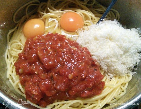 Когда спагетти чуть остынут, вмешать яйца, большую часть натертого на мелкой терке пармезана и томатного соуса. Немного сыра и соуса я оставила для посыпки и подачи. 