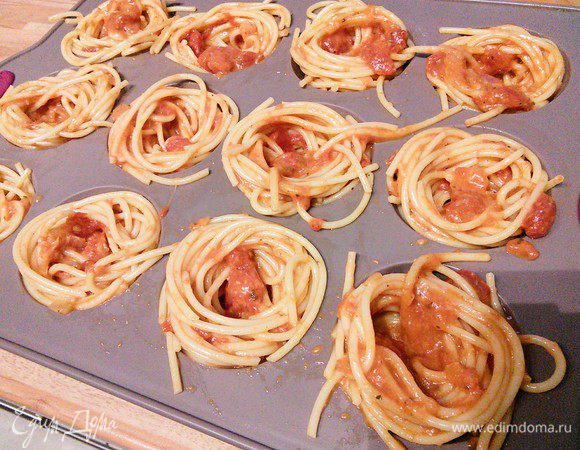 Формочки для маффинов смазать маслом (у меня силиконовая, поэтому я это упустила). С помощью вилки, наматывая на нее спагетти, выложить гнезда со свободной серединкой.  Спагетти хватило ровно на 12 формочек. 