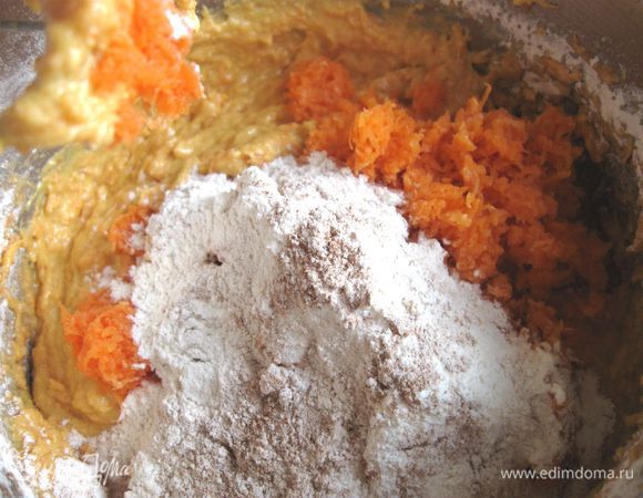 Духовку разогреть до 180°С. Просеять через сито муку с солью, корицей и пекарским порошком.  Добавить к кремообразной массе часть муки, часть моркови, перемешать миксером. Затем добавить еще часть муки и моркови, перемешать, так использовать всю муку и морковь, затем добавить орехи, перемешать миксером  до однородного состояния. 