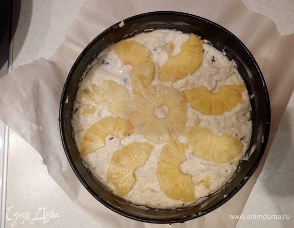 Сверху выложить веером половинки ананасовых колец, слегка вдавив их в тесто. Присыпать сверху сахарной пудрой. Отправить в предварительно разогретую до 170°С духовку на 50-55 минут.