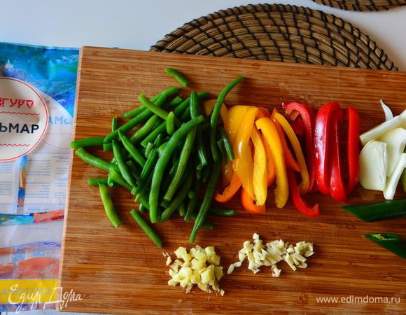 Приготовить овощи: лук нарезать вдоль, перец полосками, фасоль разморозить, чеснок и имбирь мелко нарезать, зеленый перец чили разделить пополам.