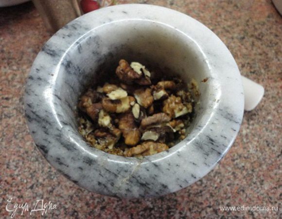 Добавить орехи и истолочь до однородного состояния. Влить винный уксус и полстакана отвара. Перемешать и переложить в сковороду к обжаренному луку. Добавить еще с полстакана отвара и тушить на медленном огне под крышкой 5-7 минут.
