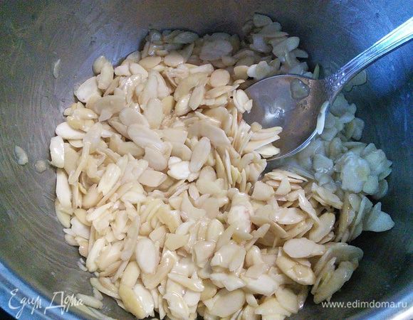 За это время сахар должен полностью раствориться, выложить в него миндальные лепестки, перемешать и снять с огня. 