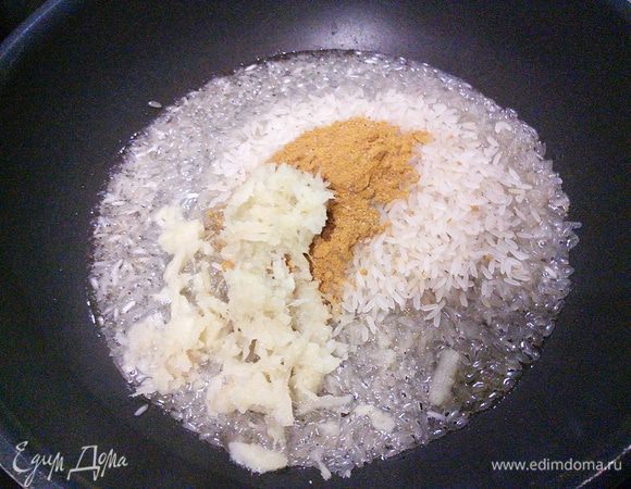 Для риса разогреть оливковое масло. Выложить в мясо натертый имбирь, карри, кардамон (предварительно раздробить коробочки кардамона и растереть семена в ступке) и рис. Размешать и прогреть, чтобы рис пропитался ароматами масла и специй.  
