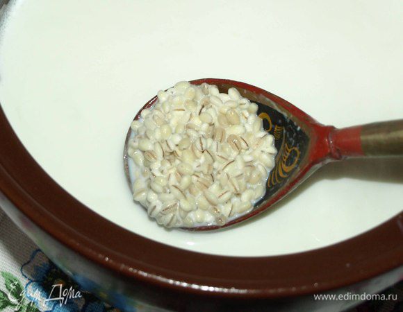 Добавить в молоко промытую крупу. Духовку разогреваем до 170-180°С. В низ духовки поставить емкость с водой.  Ставим в духовку емкость с будущей кашей. Изредка поглядывая и если, вода выкипела, то добавить воды. Осторожно открывать духовку, потому что там создается эффект паровой бани. Можно готовить просто на паровой бане без духовки.