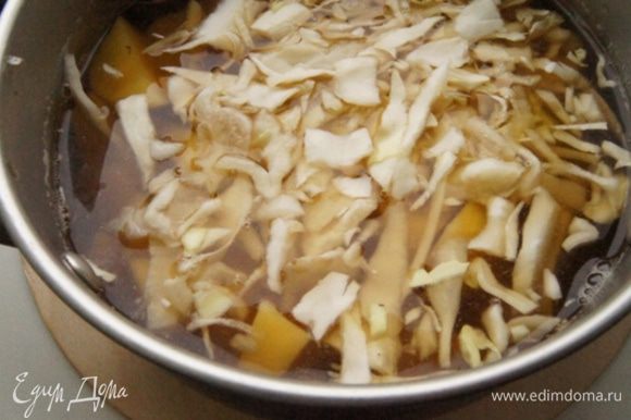 В процеженный грибной настой добавить воду. Добавить картофель, нарезанный кубиками, и нашинкованную капусту. Довести до кипения, посолить и варить минут 10.