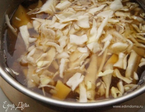 В процеженный грибной настой добавить воду. Добавить картофель, нарезанный кубиками, и нашинкованную капусту. Довести до кипения, посолить и варить минут 10.