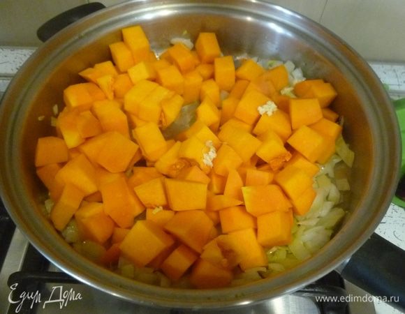 Добавить тыкву, обжарить, перемешивая. Раздавить зубчик чеснока.