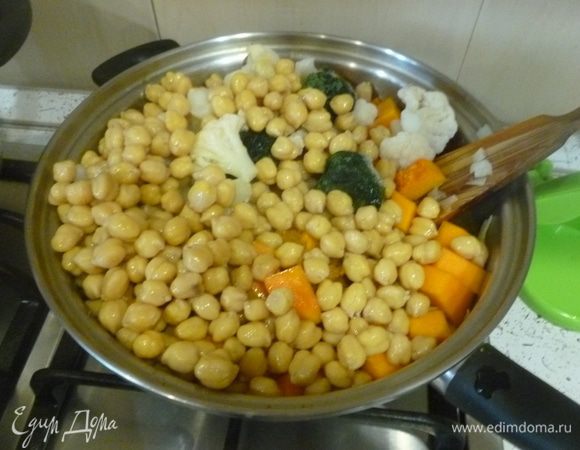 Добавить нут, цветную капусту, шпинат, пасту карри и налить немного кипятка. Готовить под крышкой, время от времени перемешивая, до готовности овощей.