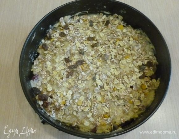 Посыпать мюсли. Поставить в духовку на 20 минут. Убавить температуру до 170°С. Выпекать еще 40 минут. Готовность проверить зубочисткой.