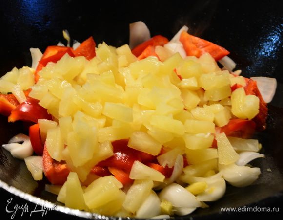 Добавить болгарский перец, кусочки консервированных ананасов. Перемешать и жарить 1-2 минуты.