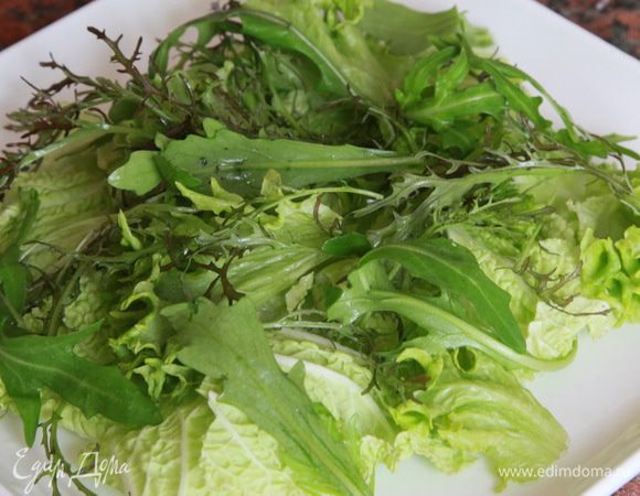 Салат айсберг разобрать на листья, порвать их не мелко, сверху выложить листья зеленого салата (если крупные — порвать), затем руколу и фриссе.