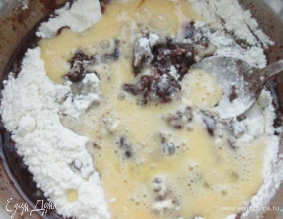 В теплую шоколадную смесь добавить муку, разрыхлитель и слегка взбитые яйца. Перемешать, чтобы не было комочков.