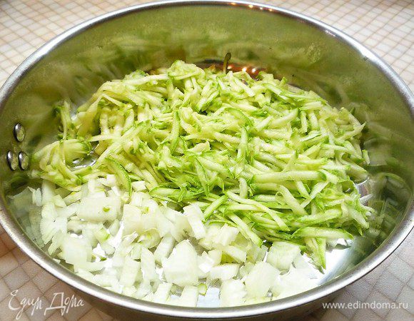 Лук мелко нарезаем, кабачок натираем на крупной терке. Обжариваем овощи на сковороде, пока не выпарится лишняя жидкость.