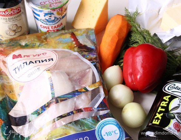 Подготавливаем ингредиенты. Филе тилапии ТМ «Магуро» промыть, разрезать на две части каждое. Почистить морковь, лук. 
Режем лук полукольцами. Морковь натираем на крупной терке. 
Разогреваем духовку до 200°С.