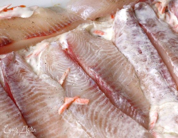 Разрезанные на две части каждое выкладываем на получившуюся «подушку» филе тилапии ТМ «Магуро». Сверху солим и перчим по вкусу. 