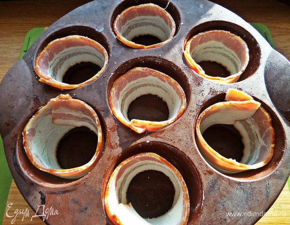 В ячейки формы для маффинов вдоль бортиков выстелить пластинки бекона.