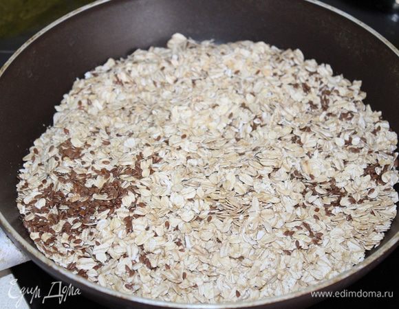 Овсяные хлопья ТМ «Националь» и льняное семя подсушить на сковороде 3-4 минуты.