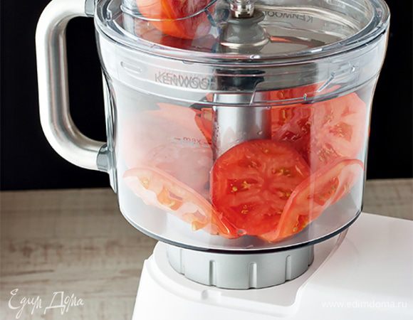 Нарежьте помидоры толстыми кружочками. Важно, чтобы они получились одинакового размера. Вы можете воспользоваться обычным ножом или же доверить эту работу насадке кухонный комбайн. С ее помощью вы получите идеально ровные и одинаковые кружочки помидора. 