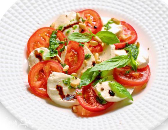 Разложите помидоры и сыр по тарелкам, чередуя друг с другом. Поперчите и подавайте вместе с соусом песто и украсив листиками базилика.