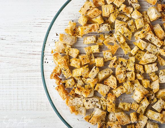 Посыпьте хлеб прованскими травами, полейте 2 ст. л. оливкового масла и поставьте в разогретую до 180 °С духовку на 10–12 минут, чтобы гренки стали хрустящими и золотистыми.
