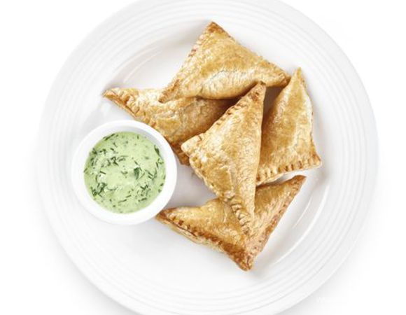 Для соуса очистите огурец от кожицы и измельчите его с зеленью, йогуртом и солью. Подавайте к пирожкам.