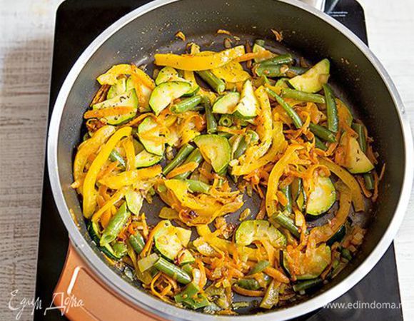 Разогрейте в глубокой сковороде 3 ст. л. оливкового масла и обжарьте на нем лук и чеснок до золотистого цвета. Добавьте в сковороду натертые овощи к луку с чесноком. Киньте туда
же перец чили, тимьян, щепотку сушеных трав. Выложите фузилли в сковороду к овощам, перемешайте и снимите с огня. 
