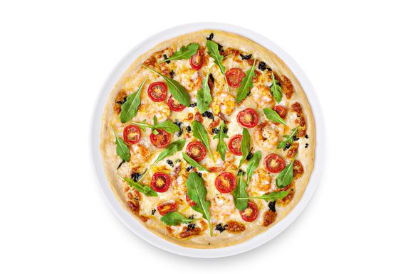 Отправьте в разогретую до 220 °С духовку на 7–10 минут. Горячую пиццу посыпьте свежей руколой.