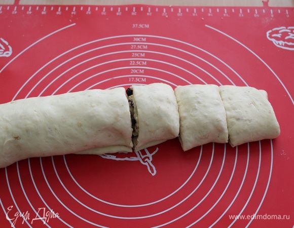 Сворачиваем лепешку в плотный рулет, режем на равные кусочки, складываем в форму и слегка присыпаем сахаром.
