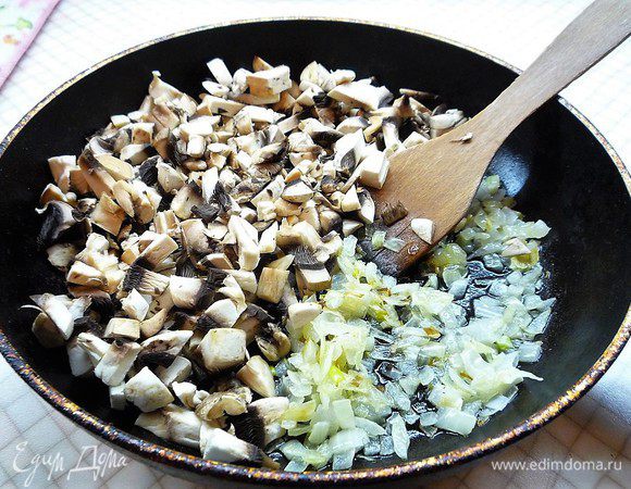 Лук мелко нарезаем и обжариваем на оливковом масле до золотистого цвета, добавляем нарезанные мелким кубиком шампиньоны.