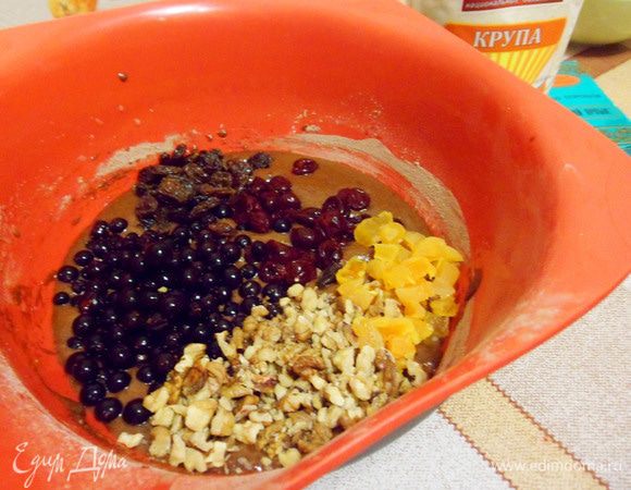 Добавить к тесту ягоды, сухофрукты и орехи. Перемешать.
