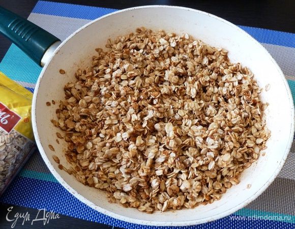 Распустим сливочное масло, всыпаем сахар и дождемся, когда он растворится и вот-вот начнет образовываться карамель. Всыпаем овсяные хлопья от ТМ «Националь» и слегка обжарим (карамелизируем) их.