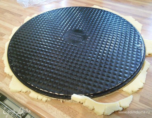 Понадобится разъемная форма диаметром 24 см. У меня — 26 см, поэтому мне пришлось в последствии обрезать корж. Из пергаментной бумаги вырезать круг, соответствующий форме, на бумаге раскатать тесто, обрезать по размеру, поместить в форму. Вилкой проделать дырочки и выпекать в заранее разогретой до 180°С духовке 15 минут. Не пересушите корж. Достать и остудить прямо в форме. 