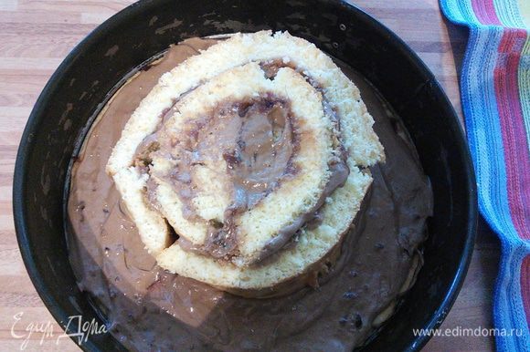 Начинаем сборку торта. Песочный корж служит донышком для конструкции. Скручивая в плотную спираль, выкладываем полосы бисквита, начиная с середины.