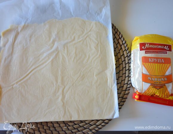 Достать тесто из холодильника и раскатать между 2-мя листами пергамента.