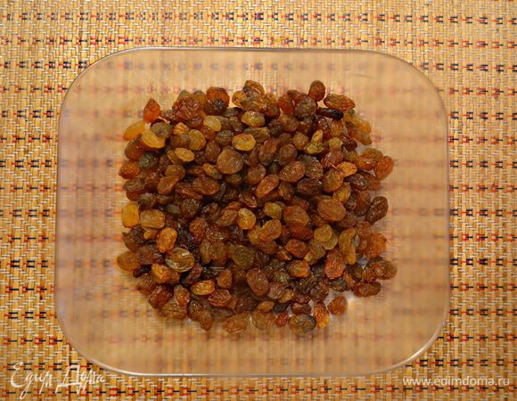 Изюм замочите на 30 мин. в теплой воде, после чего слейте воду и подсушите изюм на бумажном полотенце.