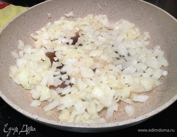 Налейте на раскаленную сковороду 2 ст. л. растительного масла и обжарьте лук до прозрачности.