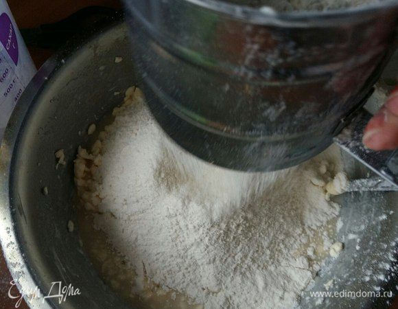 Добавить наши дрожжи, перемешать. Затем добавить просеянную муку. Добавляем постепенно, примерно по 200 граммов. Количество муки я измеряла мерным стаканом. Мне понадобилось 700 граммов. В базовом рецепте нужно просто добавить муки столько, чтобы замесить не крутое тесто.