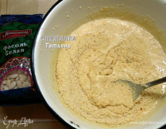 К желткам добавляем фасоль, перемешиваем. Затем соединенные с разрыхлителем измельченные сухари. Очень хорошо перемешиваем.