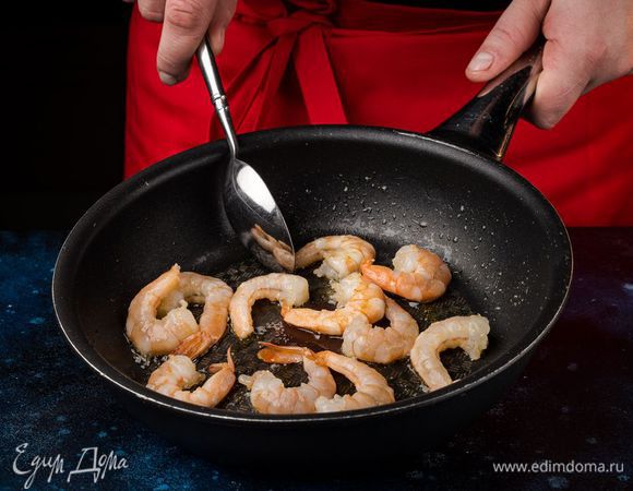 Поставьте сковородку на огонь, хорошо ее нагрейте и смажьте тонким слоем оливкового масла. Выложите очищенные креветки и слегка их обжарьте в течение 2 минут.
