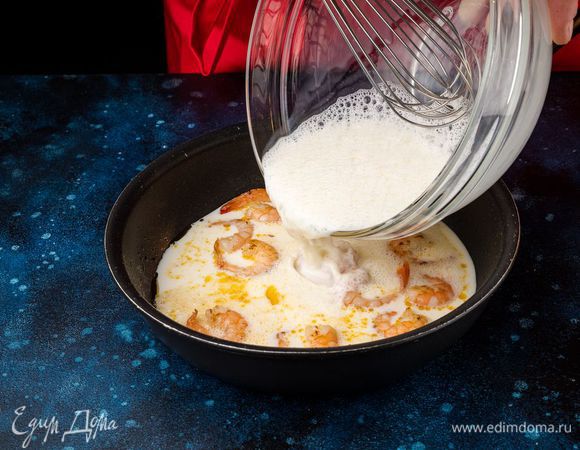 Вылейте взбитую молочно-яичную смесь к креветкам и интенсивно их перемешивайте в течение 2 минут, пока омлет не загустеет.